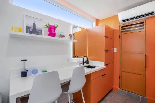 a kitchen with orange and white cabinets and a sink at Orange Container @EADO Juice Box in Houston