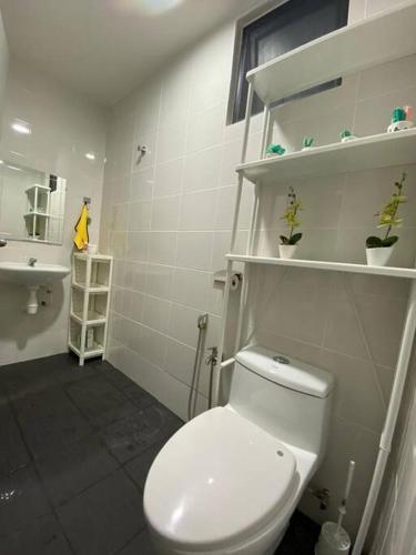 y baño con aseo blanco y lavamanos. en Family friendly multiple Parking 3bedroom apartment, en Seri Kembangan