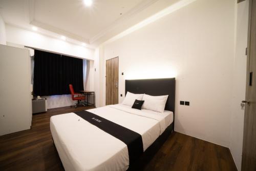 1 dormitorio con 1 cama blanca grande y cabecero negro en DS Colive Sinabung en Candi