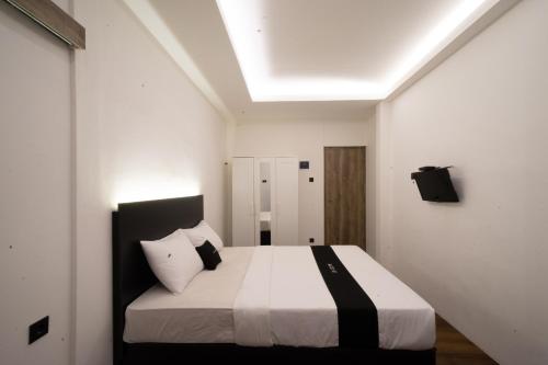 a bedroom with a bed with a black and white comforter at DS Colive Sinabung in Candi