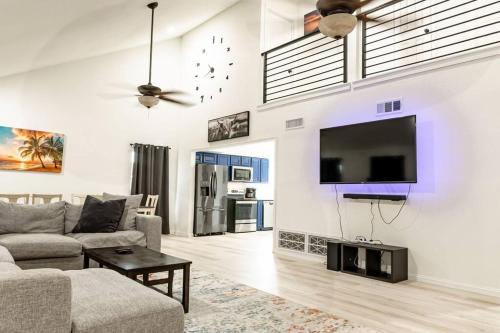 a living room with a couch and a tv on a wall at Roomy Home 5 mins from attractions in Galveston