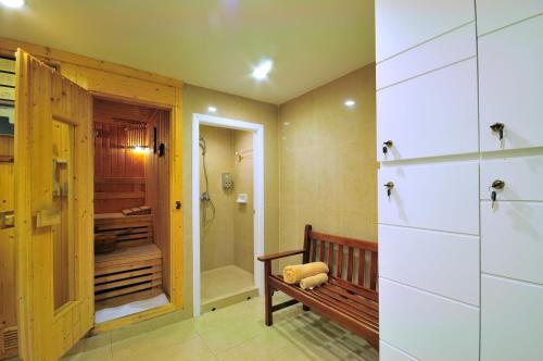 a bathroom with a bench and a walk in shower at Centre Point Pratunam in Bangkok