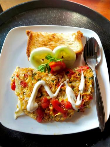 a white plate of food with a fork and toast at The Alam Bungalow & Restaurant in Tetebatu