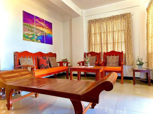 een woonkamer met stoelen en een houten tafel bij Vacation House in Baguio with Amazing Sunset Views in Baguio