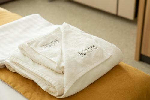 twee witte handdoeken bovenop een tafel bij Hotel Forum City in Pazardzhik