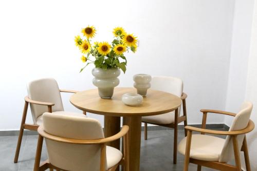 un jarrón de girasoles sentado en una mesa con sillas en The Oak Hotel, en Keramotí