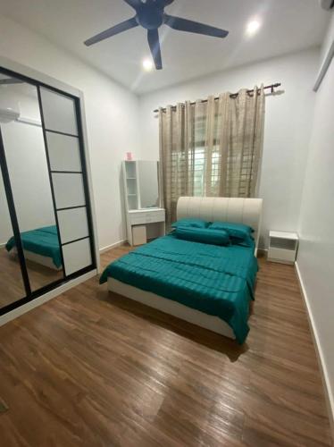 1 dormitorio con 1 cama y ventilador de techo en Amani Homestay en Kuantan