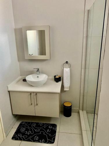 a bathroom with a sink and a mirror and a shower at Ladybug unit 3 (2) in Midrand