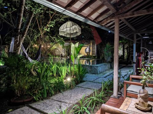 un patio con mesa, bancos y plantas en Astuti Gallery Homestay, en Yogyakarta