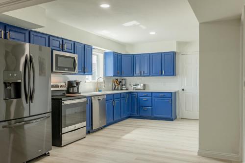 a blue kitchen with stainless steel appliances and blue cabinets at Roomy Home 5 mins from attractions in Galveston