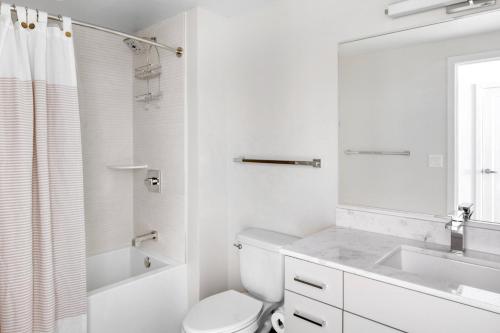 a white bathroom with a toilet and a sink at NoMa studio w wd concierge gym nr Metro WDC-643 in Washington, D.C.