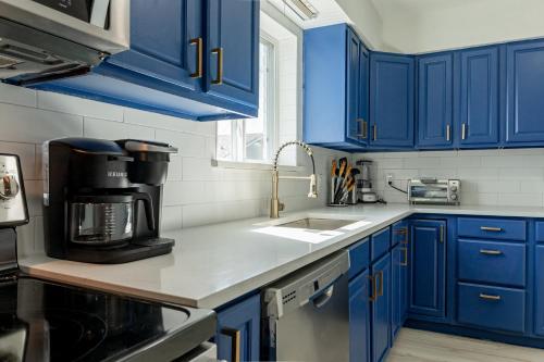 uma cozinha com armários azuis e um lavatório em Roomy Home 5 mins from attractions em Galveston