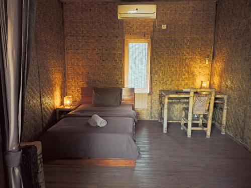 a bedroom with a bed and a desk and a table at Old Village Gili Air in Gili Air