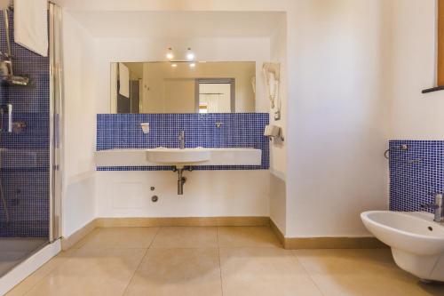 a bathroom with a sink and a toilet and a mirror at Villa Mazzella in Procida