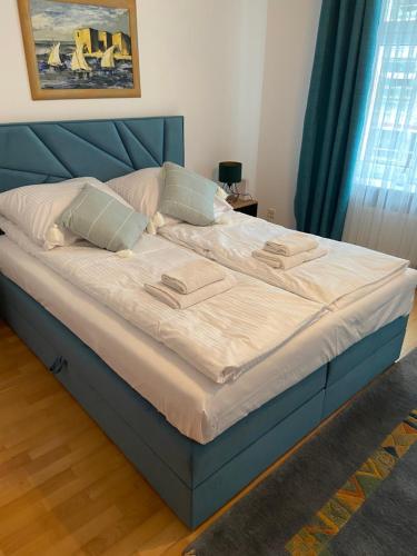 グダニスクにあるKauris Apartamentのベッドルームに大型ベッド1台(青いヘッドボード付)