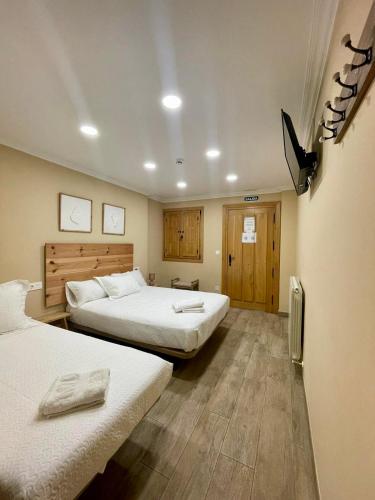 a hotel room with two beds and wooden floors at Caserio Kamirune in Laukiz