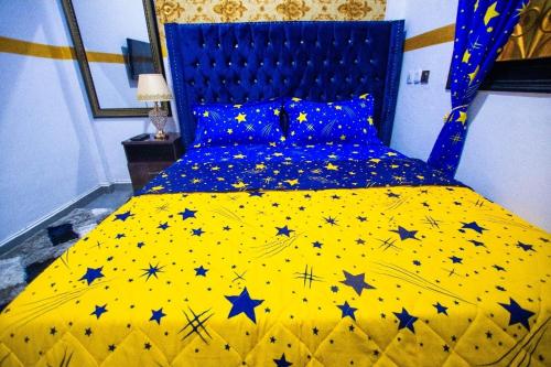 sypialnia z żółtym łóżkiem z gwiazdkami w obiekcie Appartement meublé w mieście Duala
