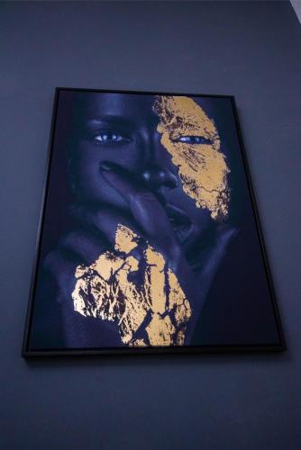 a framed picture of a woman on a wall at Appartement meublé in Douala