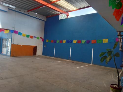 a room with a blue wall with flags on it at Hotel Eucaliptos De Mauro in Oaxaca City