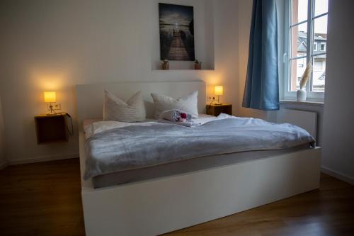 a white bed with a teddy bear sitting on it at Suite Barrique Zell in Zell an der Mosel