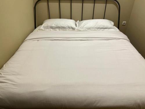 a large white bed with two pillows on it at Choska Residence in Jakarta
