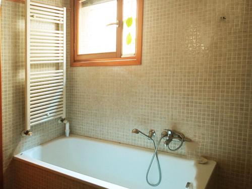 uma banheira na casa de banho com uma janela em Immersa nel verde em Veneza
