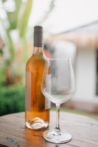 a bottle of wine sitting next to a wine glass at EHOA NYANYI BEACH Boutique Hotel - In front of entrance to NUANU in Tanah Lot