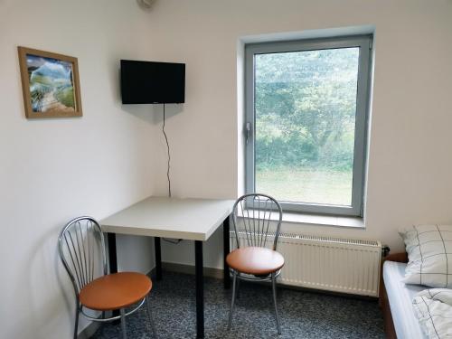 Cette chambre dispose d'un bureau, de deux chaises et d'une fenêtre. dans l'établissement Opaa Motel, à Poniatowa