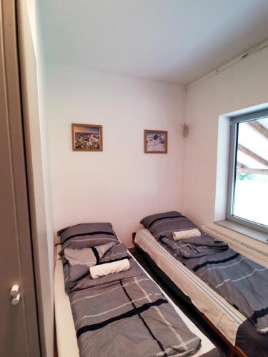 two beds in a room with a window at Opaa Motel in Poniatowa