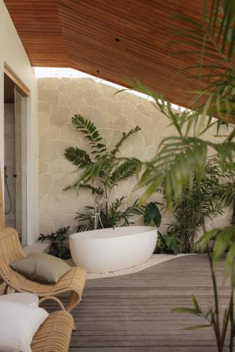 a room with plants and a large bowl on the wall at Sage Villas Bingin in Uluwatu