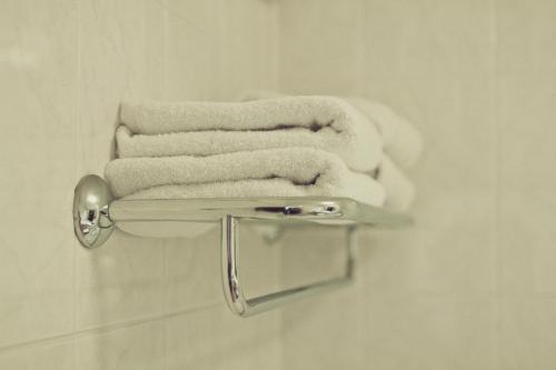 três toalhas num toalheiro na casa de banho em Abbey Lodge Hotel em High Wycombe