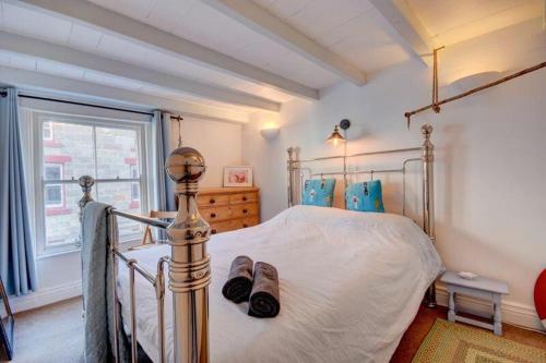 a bedroom with a bed with two slippers on it at Johnny Reb Cottage In the heart of Staithes in Staithes