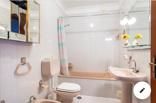 a bathroom with a toilet and a sink and a tub at Amorosa Viana do Castelo in Viana do Castelo