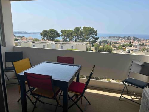 une table et des chaises dans une pièce avec une grande fenêtre dans l'établissement Studio les nautiles Bandol, à Bandol