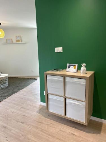 - une table dans une pièce dotée d'un mur vert dans l'établissement Appart le 201 Jasseron, à Jasseron