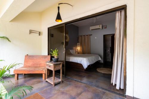 a bedroom with a bed and a table in a room at The Banyan Soul in Anjuna