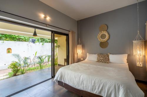 a bedroom with a bed and a large window at The Banyan Soul in Anjuna