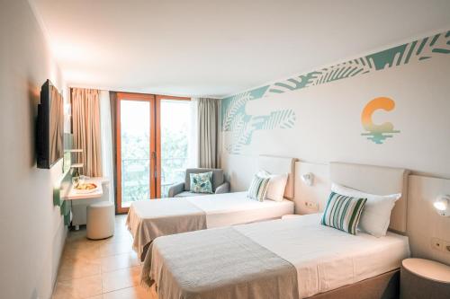 a hotel room with two beds and a window at Calimera Ralitsa Superior Hotel - Ultra All Inclusive plus Aquapark in Albena