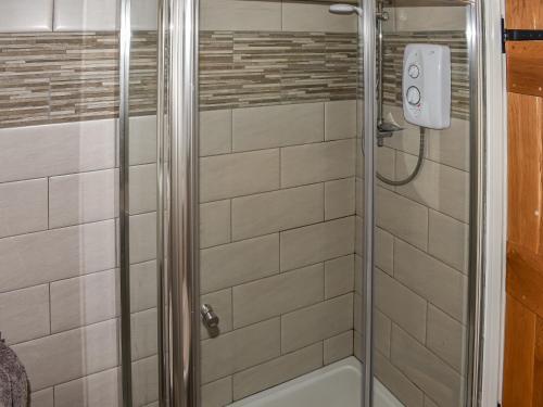 a shower in a bathroom with white tiles at 1 The Old Corn Mill in Middleham