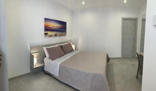 a bedroom with a bed and a painting on the wall at Tenuta Verdolivo in Ostuni