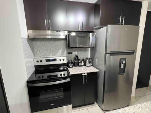 a kitchen with a stove and a refrigerator at Modern Condo in Ecovivienda in Tegucigalpa
