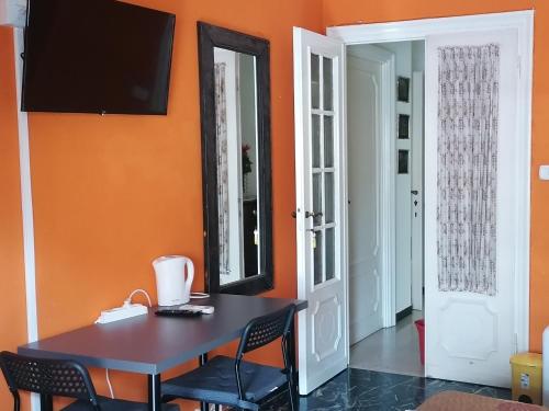 een eetkamer met oranje muren en een tafel en stoelen bij Céline in Genua