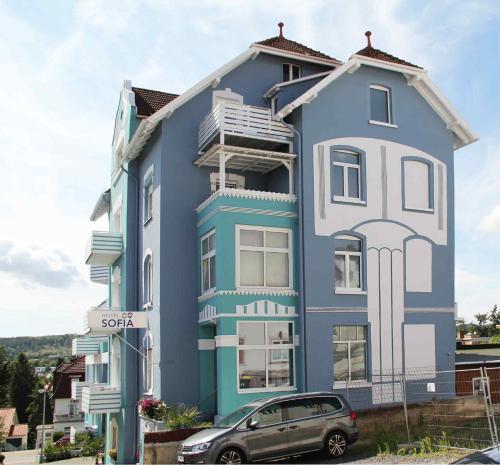 a blue house with a car parked in front of it at Hotel Sofia in Bad Wildungen