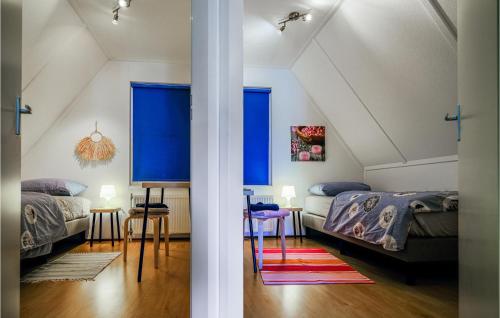 sypialnia z 2 łóżkami i niebieskimi oknami w obiekcie 4 Bedroom Cozy Home In Zonnemaire w mieście Zonnemaire