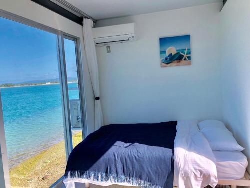 1 dormitorio con 1 cama y vistas al océano en Nel Beach Rosso / Vacation STAY 17520, en Nago
