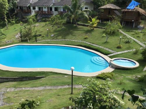 an image of a swimming pool in a yard at Cuestas Beach Resort and Restaurant in Badian