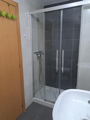 uma cabina de duche em vidro na casa de banho com um lavatório em Apartamento en Badames em Bádames