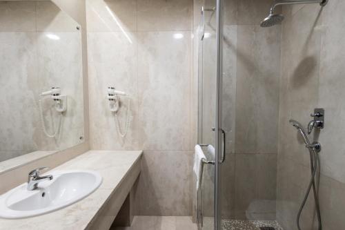 a bathroom with a sink and a shower at GARNI HOTEL AMI in Novi Sad