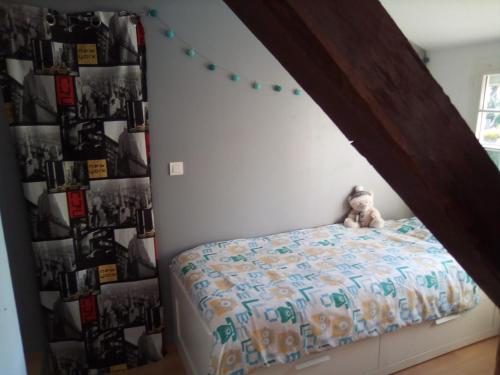 um quarto com uma cama com um urso de peluche em MAISON DU CLOCHER em Le Planquay