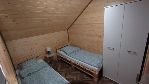 a small room with two beds in a cabin at SOSNOWY ZAKĄTEK in Okuninka